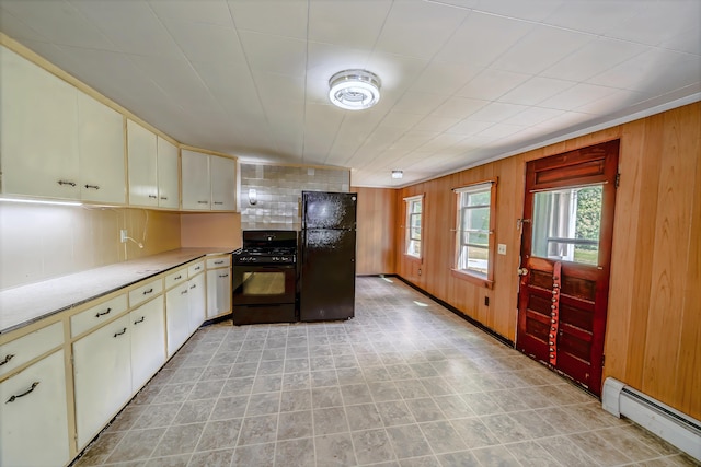 176 Bagley Hill Rd, Troy, ME 04987 - kitchen with black appliances, a baseboard radiator, healthy amount of natural light, cream cabinetry, and wooden walls