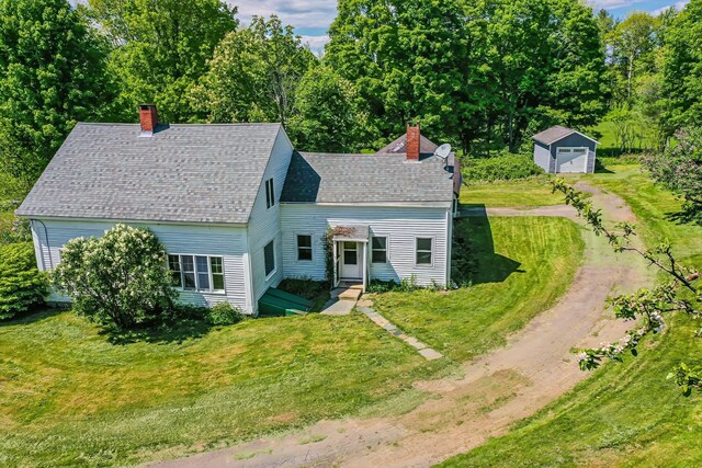 176 Bagley Hill Rd, Troy, ME 04987 - view of front of house featuring a chimney, an outbuilding, and a front lawn