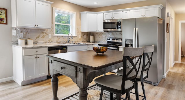 51 Stearns Farm Rd, Hampden, ME 04444 - kitchen with appliances with stainless steel finishes, a sink, light wood-style flooring, baseboards, and white cabinetry