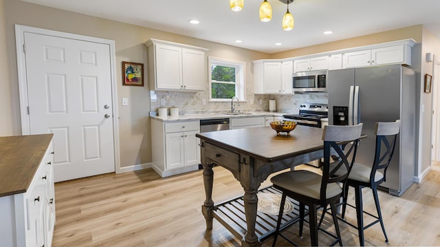 51 Stearns Farm Rd, Hampden, ME 04444 - kitchen with appliances with stainless steel finishes, a sink, light wood-type flooring, white cabinetry, and tasteful backsplash