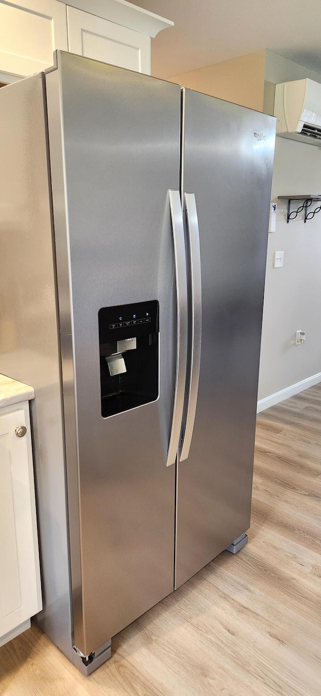 51 Stearns Farm Rd, Hampden, ME 04444 - detailed view of stainless steel fridge, light wood-style floors, white cabinetry, and light countertops
