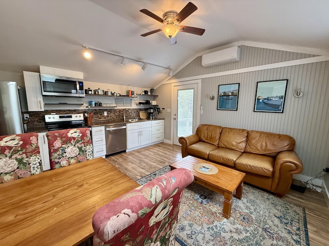 40 Shorebreezes Ln Unit 40, Kennebunk, ME 04043 - living area featuring a wall unit AC, light wood-style floors, vaulted ceiling, ceiling fan, and rail lighting