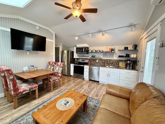 40 Shorebreezes Ln Unit 40, Kennebunk, ME 04043 - living room with vaulted ceiling, rail lighting, light wood-type flooring, ceiling fan, and a skylight