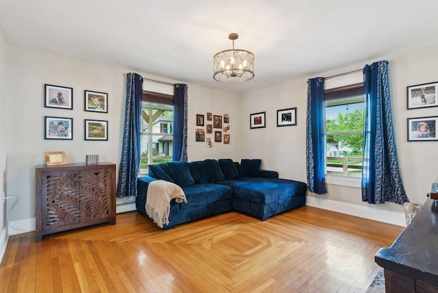 124 Dumont Ave, Lewiston, ME 04240 - living room featuring a chandelier, a baseboard heating unit, baseboards, and light wood-type flooring