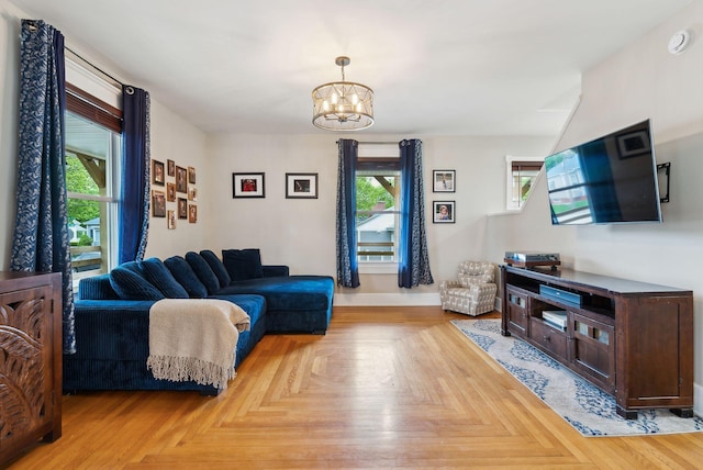 124 Dumont Ave, Lewiston, ME 04240 - living room featuring healthy amount of natural light, a chandelier, and baseboards