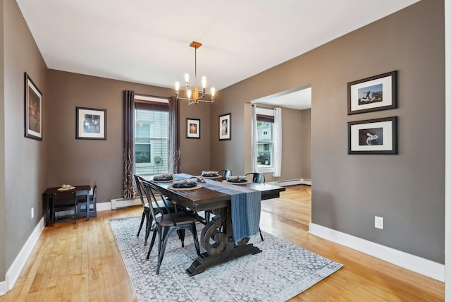 124 Dumont Ave, Lewiston, ME 04240 - dining area with plenty of natural light, a baseboard radiator, a chandelier, and light wood-style flooring