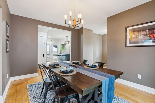 124 Dumont Ave, Lewiston, ME 04240 - dining area featuring a chandelier, light wood-style flooring, and baseboards