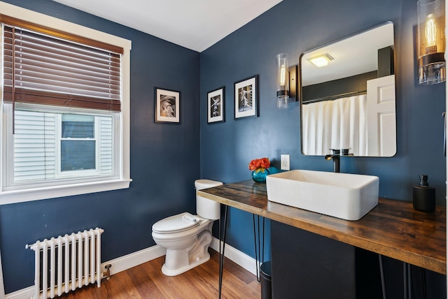 124 Dumont Ave, Lewiston, ME 04240 - full bathroom featuring radiator heating unit, baseboards, toilet, wood finished floors, and vanity