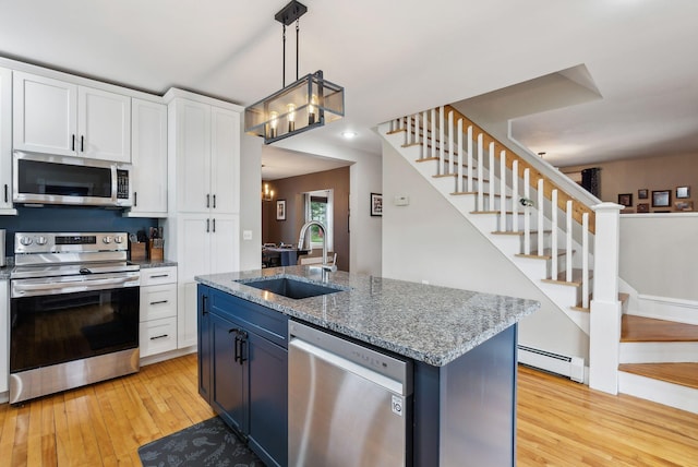 124 Dumont Ave, Lewiston, ME 04240 - kitchen with appliances with stainless steel finishes, a sink, light wood finished floors, a baseboard radiator, and white cabinets