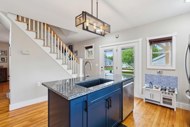 124 Dumont Ave, Lewiston, ME 04240 - kitchen with a sink, stainless steel dishwasher, blue cabinetry, and light wood-type flooring