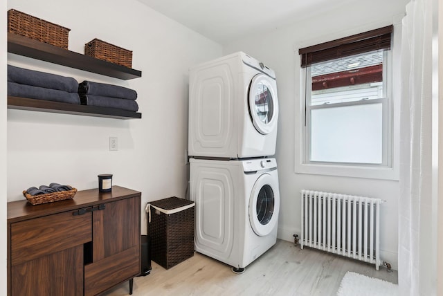 124 Dumont Ave, Lewiston, ME 04240 - laundry area featuring radiator heating unit, estacked washer and dryer, and light wood-style floors