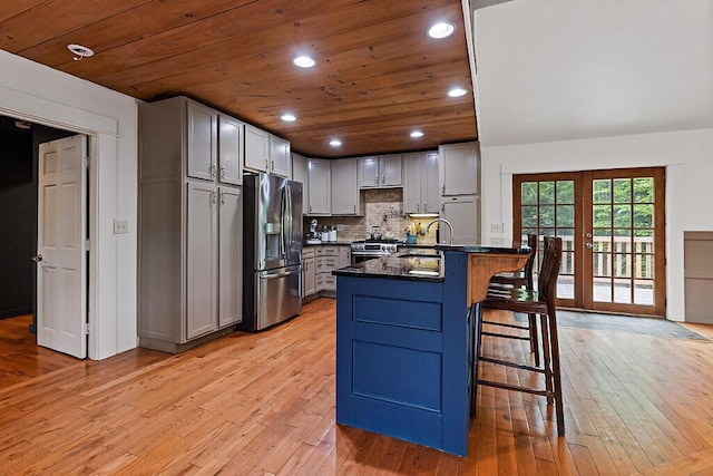 39 Lobo Ln, West Gardiner, ME 04345 - kitchen featuring stainless steel appliances, dark countertops, light wood-style flooring, a breakfast bar area, and a peninsula