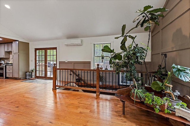 39 Lobo Ln, West Gardiner, ME 04345 - living room with a wall mounted air conditioner, vaulted ceiling, french doors, and light wood-style floors