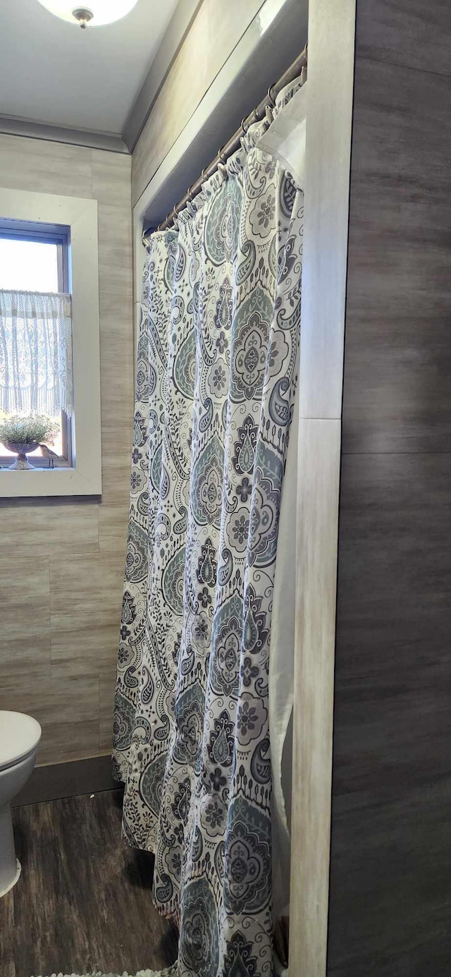 110 Bog Rd, Limestone, ME 04750 - bathroom with tile walls, toilet, wood finished floors, and curtained shower