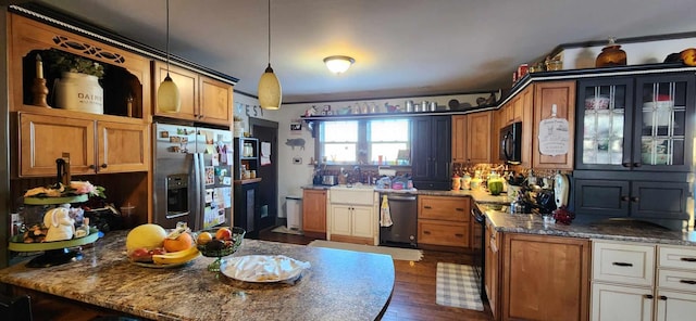 110 Bog Rd, Limestone, ME 04750 - kitchen featuring stainless steel appliances, a peninsula, a sink, dark wood-style floors, and decorative light fixtures