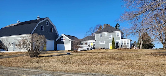 110 Bog Rd, Limestone, ME 04750 - view of side of home with a chimney, a garage, and a gambrel roof