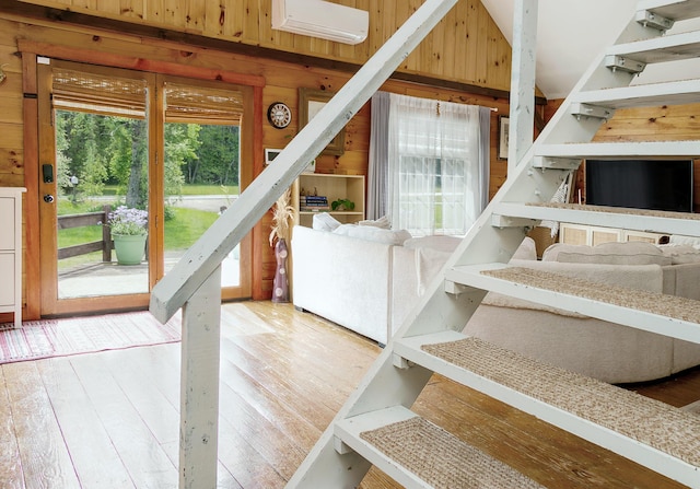 313 Sam Allen Rd, Sanford, ME 04073 - staircase with a wall mounted air conditioner, wood walls, and wood-type flooring