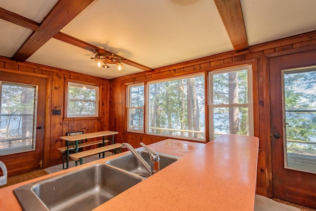 54 Papoose Island Rd, Raymond, ME 04071 - kitchen with beam ceiling, wooden walls, a sink, a ceiling fan, and light countertops