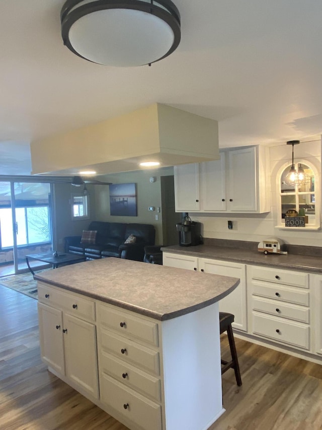 476 Springy Pond Rd, Otis, ME 04605 - kitchen with dark wood-style floors, a kitchen island, and white cabinetry