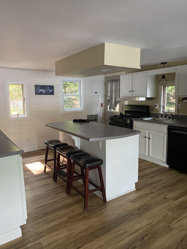 476 Springy Pond Rd, Otis, ME 04605 - kitchen with black dishwasher, range with gas stovetop, dark wood-style flooring, a kitchen island, and white cabinetry