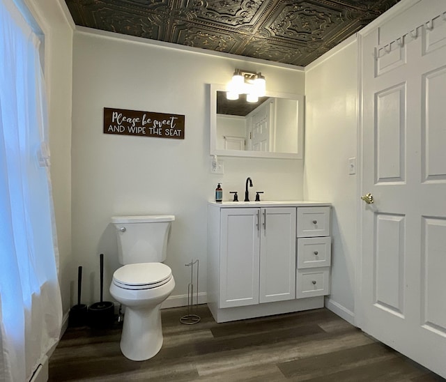 3 Brook St, Lisbon, ME 04250 - half bath with an ornate ceiling, vanity, wood finished floors, toilet, and baseboards