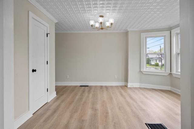 50 14th St, Bangor, ME 04401 - spare room with crown molding, a chandelier, light wood-style floors, an ornate ceiling, and baseboards
