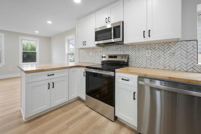50 14th St, Bangor, ME 04401 - kitchen with butcher block countertops, stainless steel appliances, a peninsula, and recessed lighting