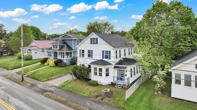 50 14th St, Bangor, ME 04401 - view of front facade featuring roof with shingles, a front yard, and a chimney