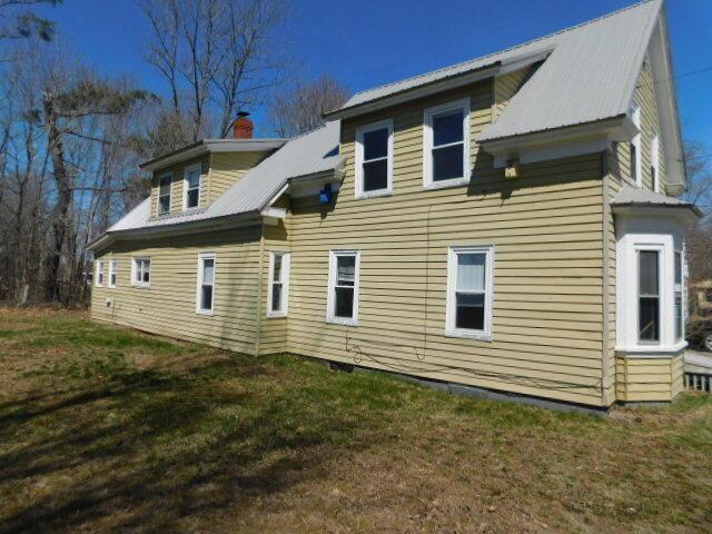 10 Summer St, Calais, ME 04619 - rear view of property with a yard, metal roof, and a chimney