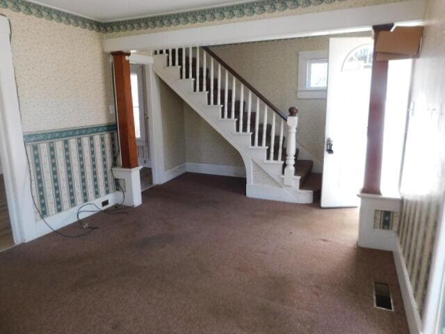 10 Summer St, Calais, ME 04619 - unfurnished living room with wallpapered walls, carpet, and stairway