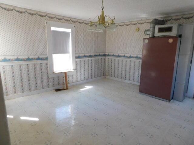 10 Summer St, Calais, ME 04619 - spare room with a chandelier, tile patterned floors, and wallpapered walls