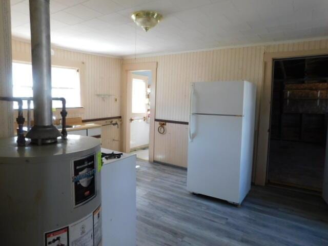 10 Summer St, Calais, ME 04619 - kitchen featuring freestanding refrigerator, crown molding, wood finished floors, and water heater