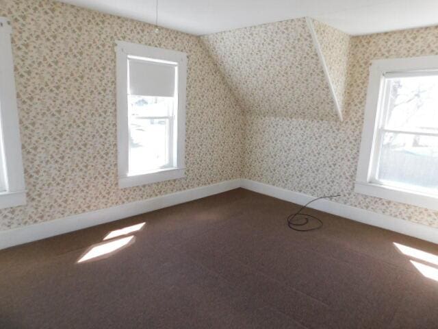 10 Summer St, Calais, ME 04619 - bonus room with healthy amount of natural light, wallpapered walls, dark carpet, and baseboards