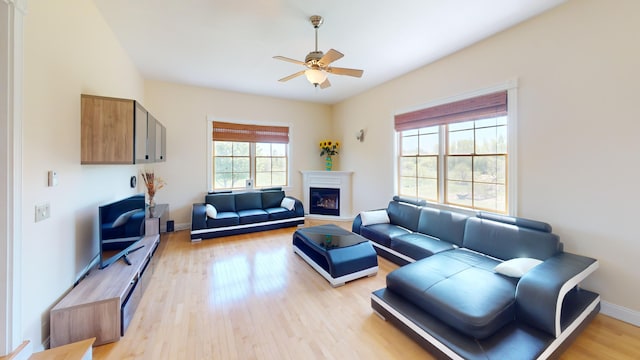 335 Western Ave, Hampden, ME 04444 - living room featuring ceiling fan, a glass covered fireplace, light wood-style floors, and baseboards