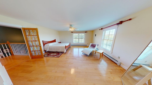 335 Western Ave, Hampden, ME 04444 - bedroom with a baseboard heating unit, light wood finished floors, baseboard heating, and a ceiling fan