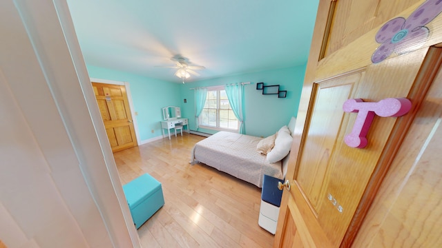 335 Western Ave, Hampden, ME 04444 - bedroom with light wood-type flooring, a ceiling fan, baseboards, and a baseboard heating unit