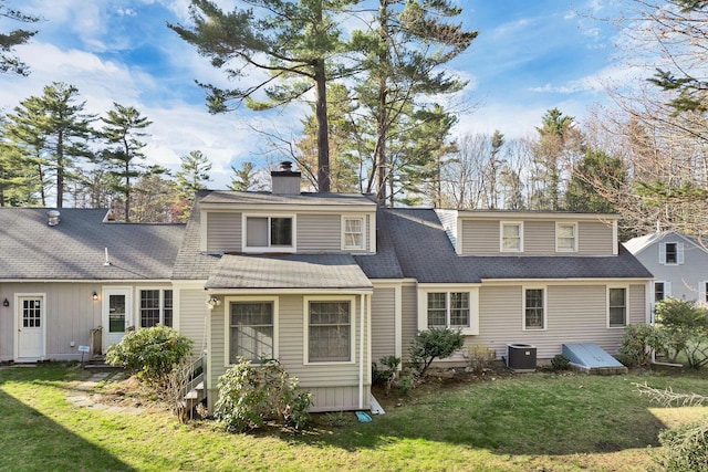 7 Acorn Cir Unit 7, Kennebunk, ME 04043 - back of house featuring a yard, central AC unit, a chimney, and roof with shingles