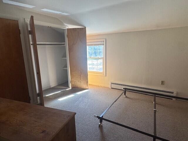 8 Sunset View St Unit 2, Gray, ME 04039 - unfurnished bedroom featuring a baseboard radiator, carpet, and a closet