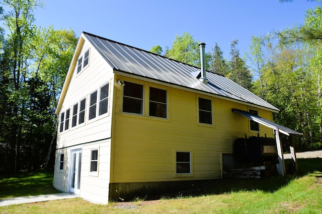 1809 Embden Pond Rd, Embden, ME 04958 - view of side of home with a lawn, a standing seam roof, and metal roof