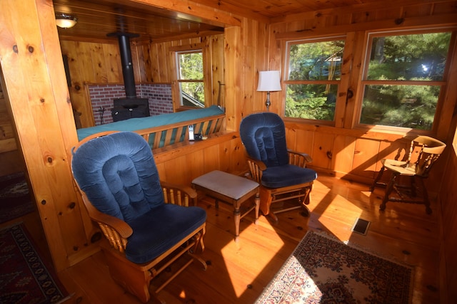1809 Embden Pond Rd, Embden, ME 04958 - living area with wood walls, wood finished floors, a wood stove, and wooden ceiling