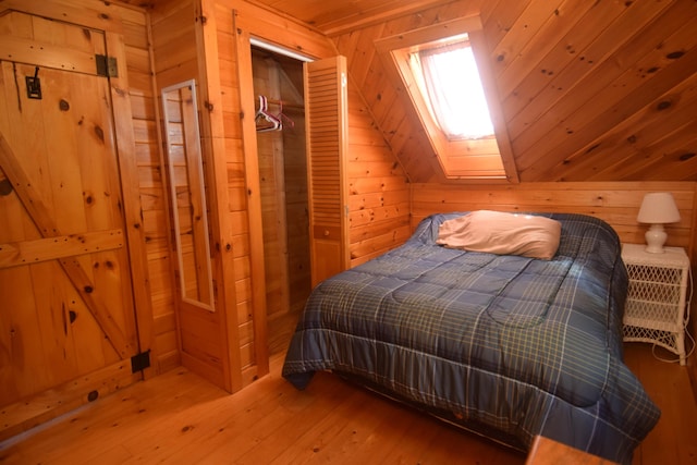 1809 Embden Pond Rd, Embden, ME 04958 - bedroom featuring wood walls, a skylight, light wood-style floors, vaulted ceiling, and wooden ceiling