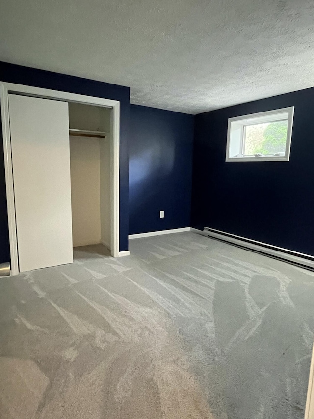 39 Thompson St, Wells, ME 04090 - unfurnished bedroom with a baseboard radiator, carpet floors, a textured ceiling, and a closet