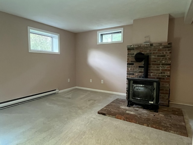 39 Thompson St, Wells, ME 04090 - unfurnished living room featuring carpet flooring, healthy amount of natural light, a wood stove, and baseboard heating
