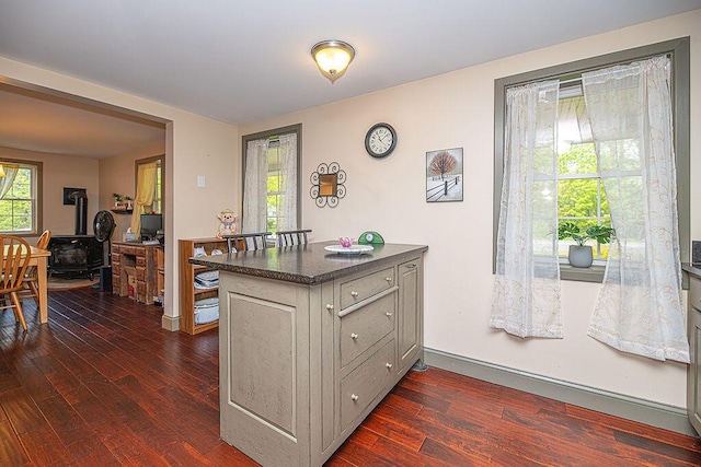 84 Little River Rd, Berwick, ME 03901 - kitchen featuring a wood stove, dark wood-style floors, dark countertops, and a peninsula