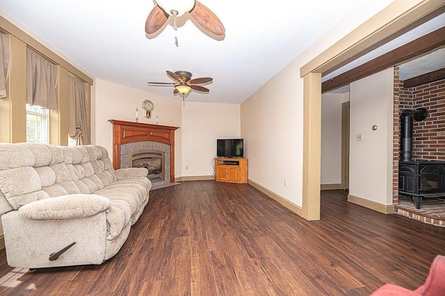 84 Little River Rd, Berwick, ME 03901 - living area featuring ceiling fan, dark wood-style floors, a fireplace with flush hearth, a wood stove, and baseboards