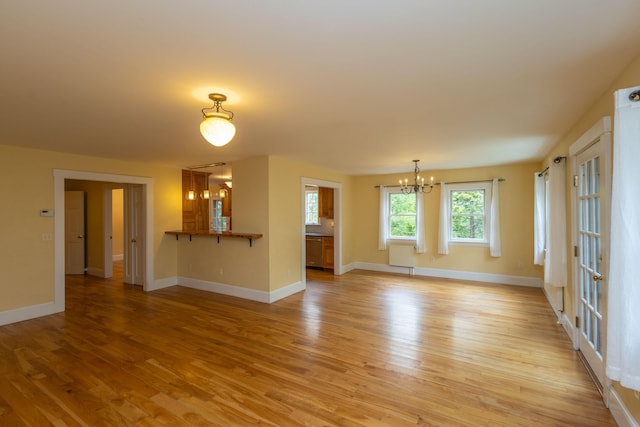 17 Spruce St, Rockport, ME 04856 - unfurnished living room with light wood finished floors, a chandelier, and baseboards