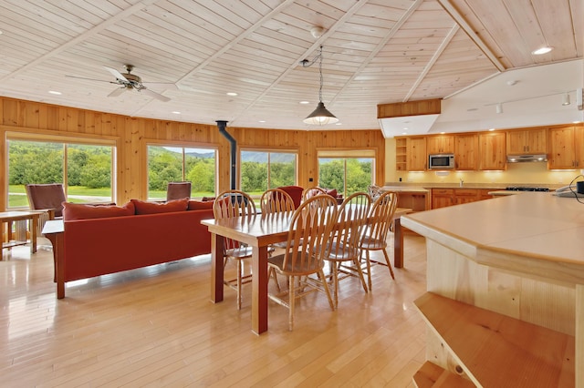 2222 Main Rd, Chatham, NH 03813 - dining area with healthy amount of natural light, wood ceiling, wooden walls, ceiling fan, and light wood-style flooring