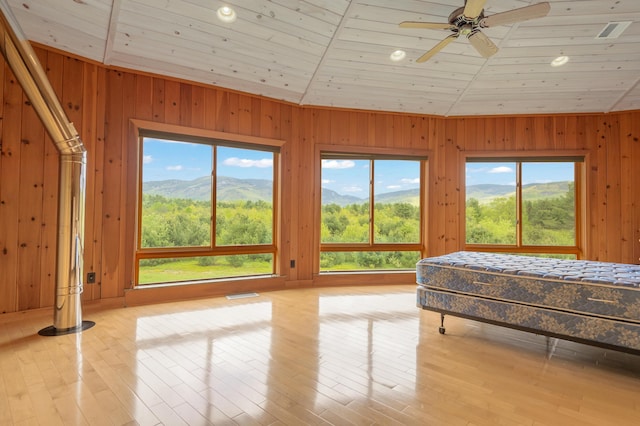 2222 Main Rd, Chatham, NH 03813 - bedroom featuring multiple windows, wooden walls, a mountain view, wood ceiling, and light wood-type flooring
