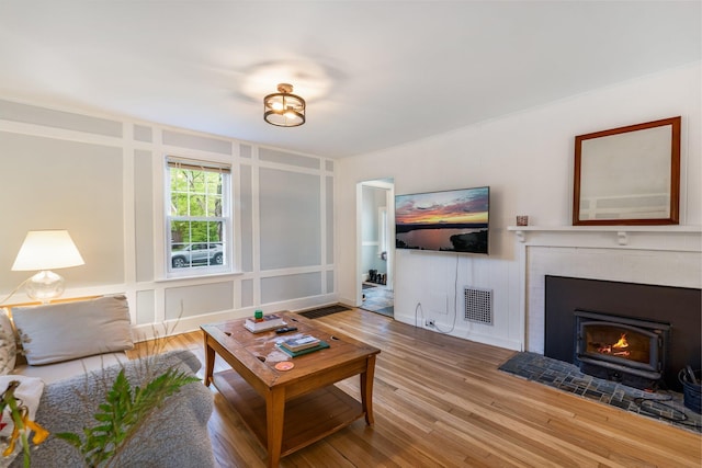 4 University Pl, Orono, ME 04473 - living room with wood finished floors, a fireplace with flush hearth, and a decorative wall