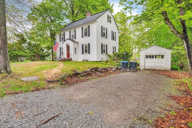 4 University Pl, Orono, ME 04473 - colonial home with a chimney, an outdoor structure, a detached garage, metal roof, and driveway
